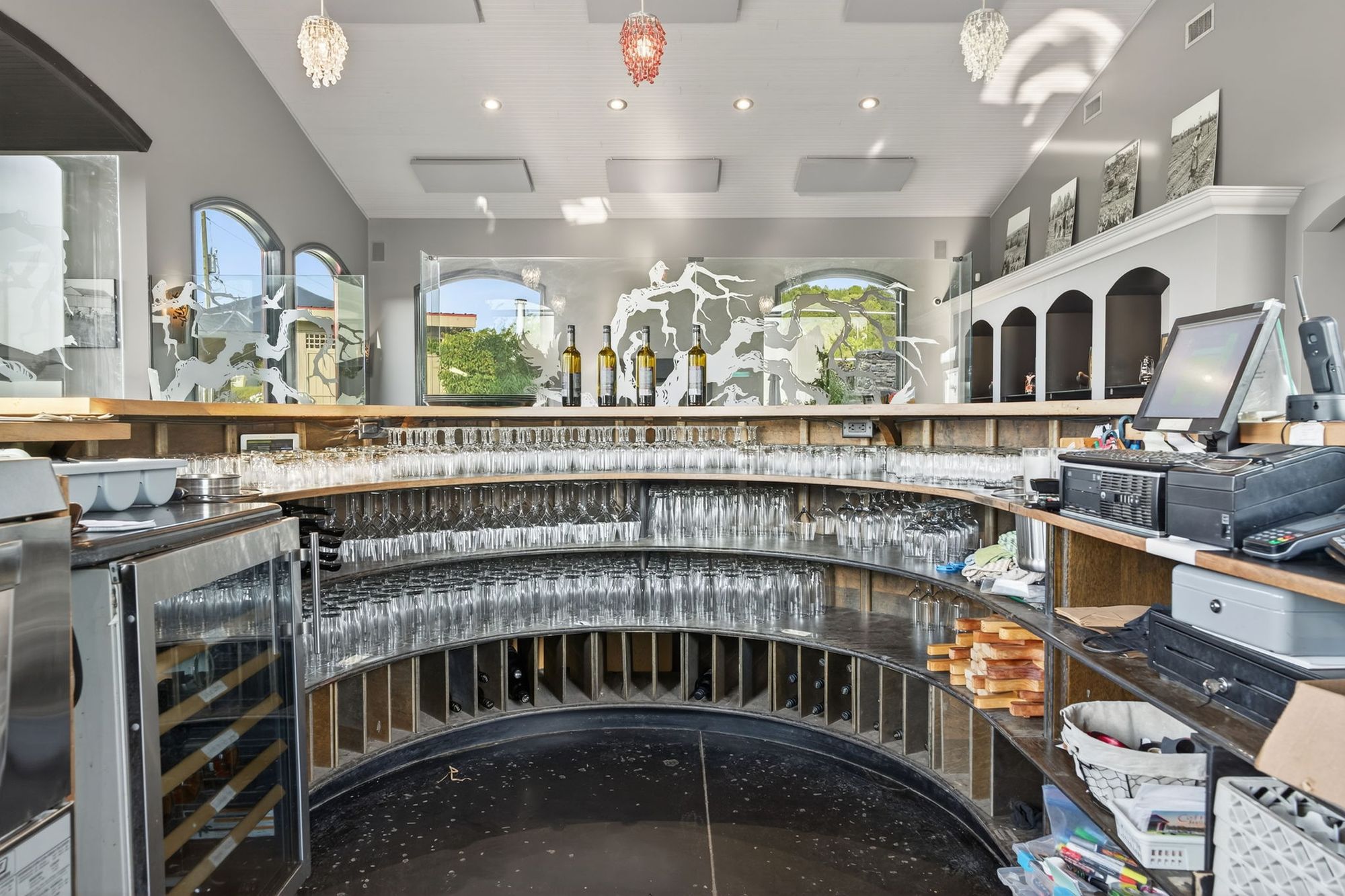 Behind the curved tasting bar, glasses racked and ready
