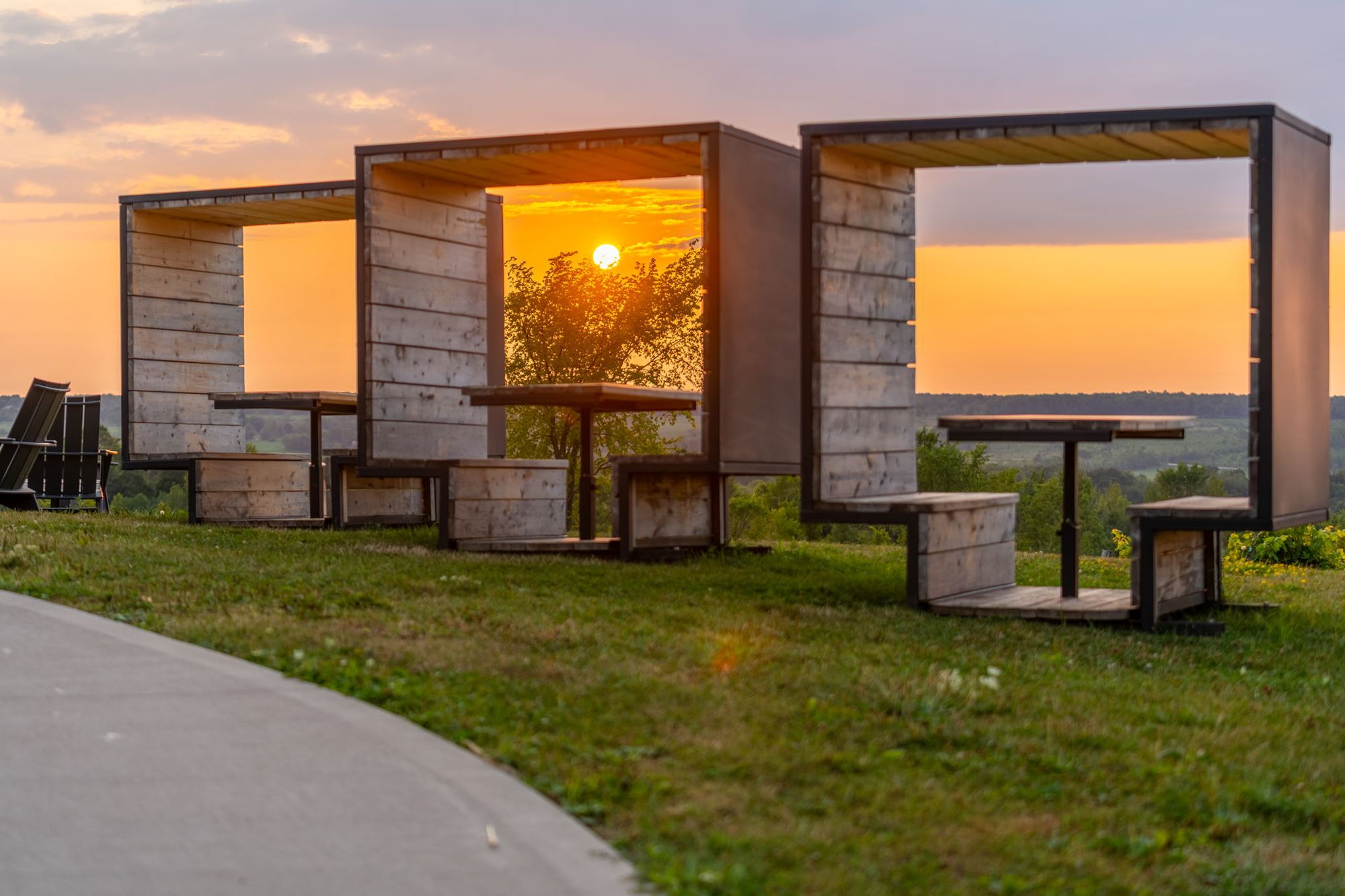 The timber frame seats on the ridge with the sun going down behind them