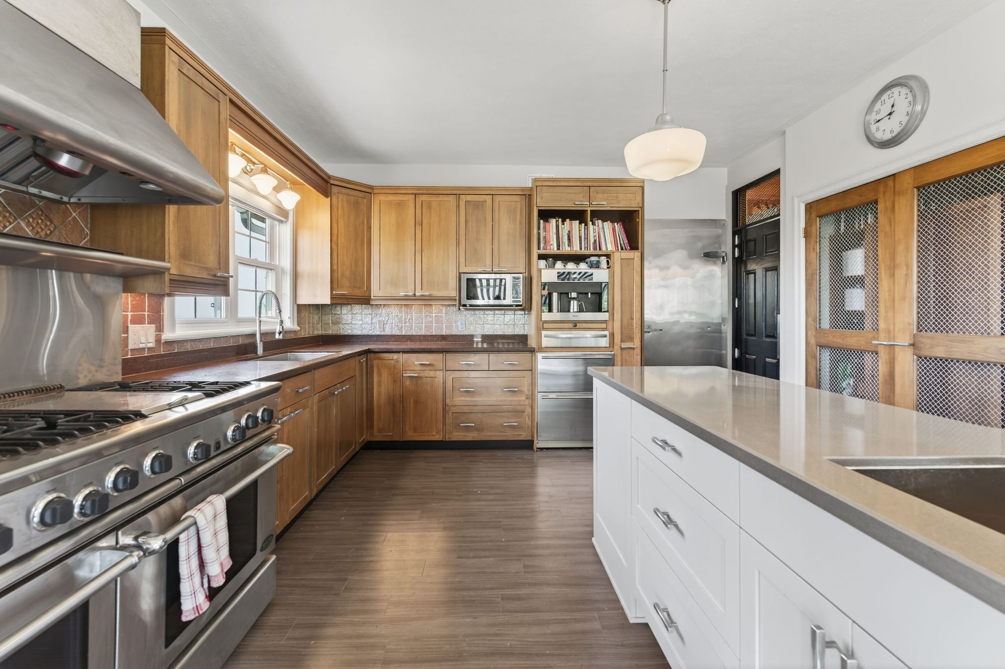 The kitchen with its professional range, island and wood cabinetry