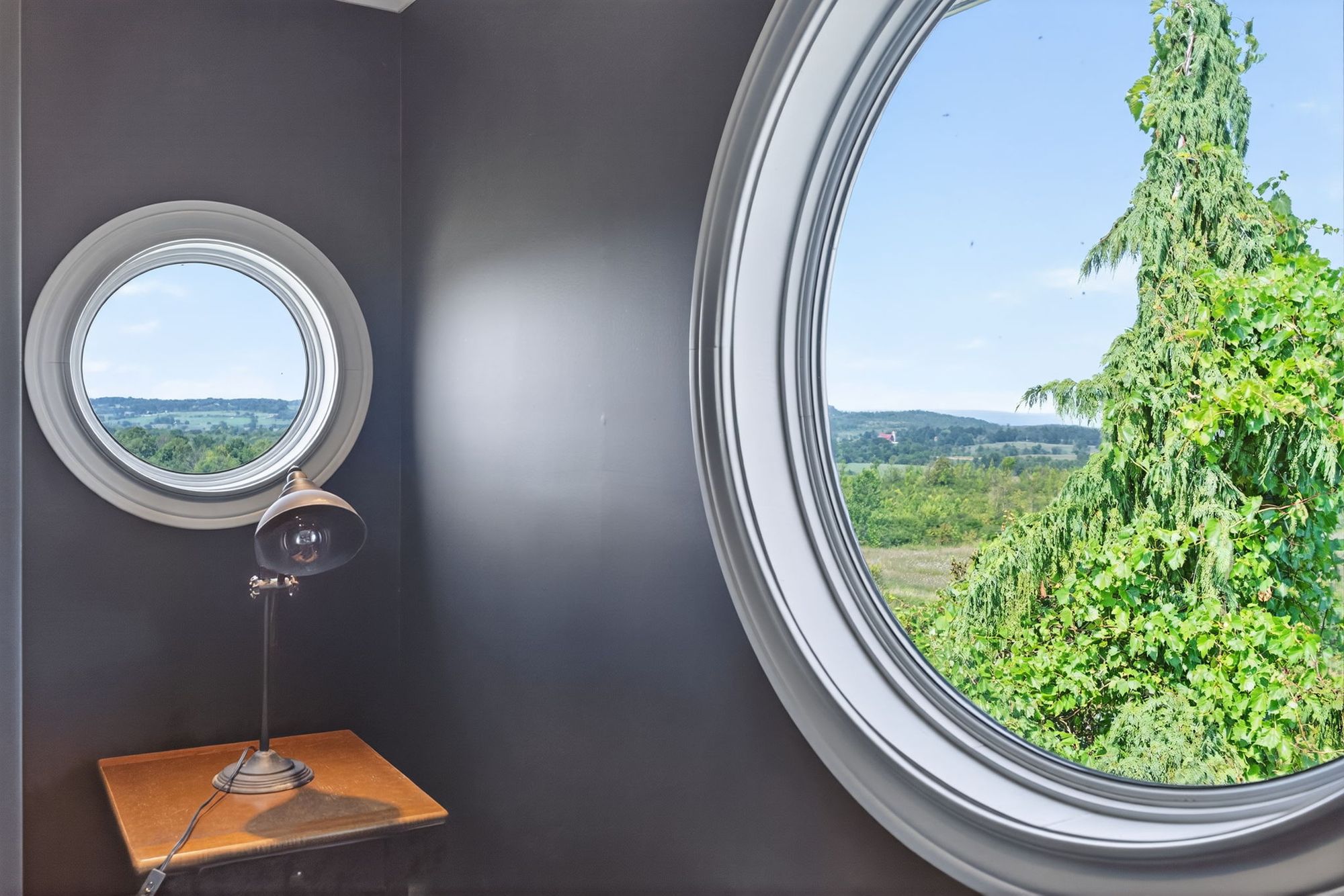 A porthole window in the study looking out to the hills